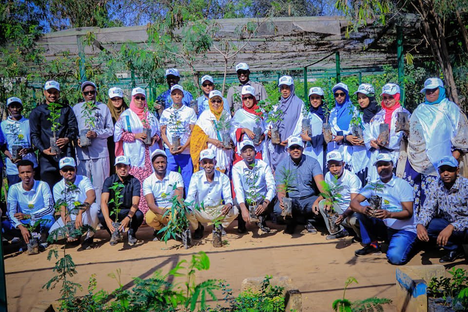 Real Hub Initiatives team and volunteers holding seedlings at a tree nursery on National Planting Day